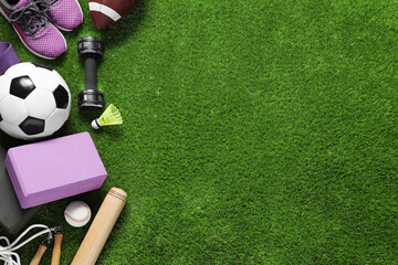 Obraz premium Different sport tools on green grass, flat lay. Space for text