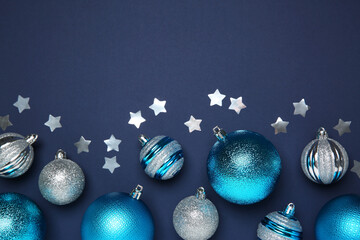 Christmas balls and confetti on dark blue background, flat lay. Space for text