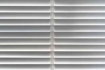 closed white venetian blinds curtain on window and morning to block light or hidden keep secretly...