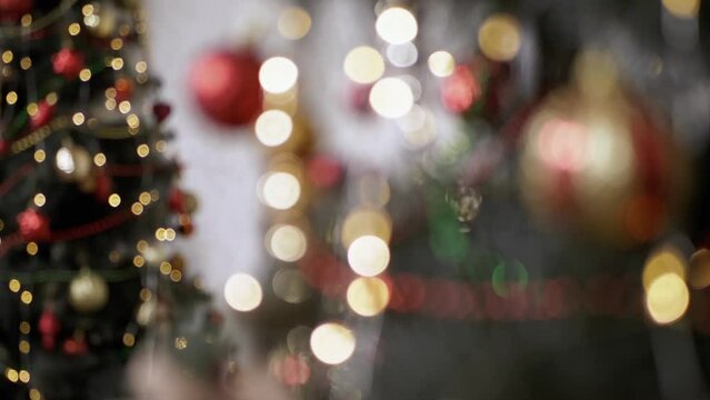 Reflection in Mirror of Twinkling Lights on a Blurred Christmas Tree Background. Defocused Christmas tree. Lots of shining, flashing golden lights, toys. Bokeh. Christmas decoration, garland. Xmas.