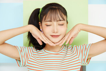 カラフルな背景で撮影をした若い女性のカジュアルなポートレート