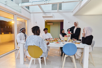 In the sacred month of Ramadan, a Muslim family joyously comes together around a table, eagerly awaiting the communal iftar, engaging in the preparation of a shared meal, and uniting in anticipation