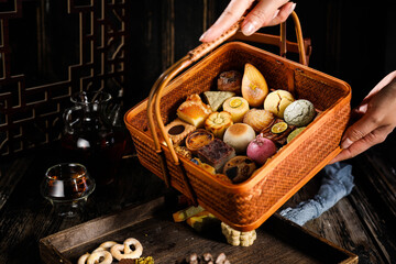 Traditional Chinese pastries on tabletop on dark background indoors with various snacks and...