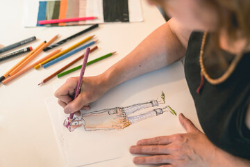Fashion designer drawing a fashion sketch with colorful pencils