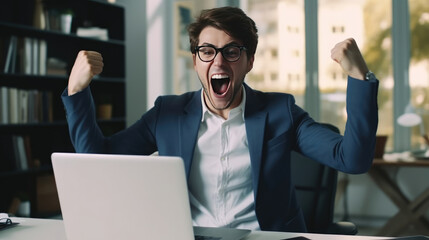 Fototapeta premium A young businesswoman in front of a laptop cheerfully celebrates success