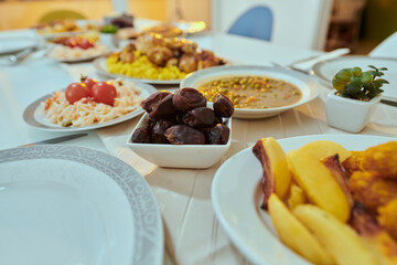A picturesque array of dates and diverse, delectable dishes adorns the table, creating a sumptuous feast ready for the Iftar meal during the sacred month of Ramadan, embodying a rich tapestry of