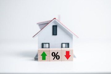 Resident rate, real estate, property and building annual taxation. percentage icon with house model and up and down arrow on wood block. House and property investment and asset management concept.