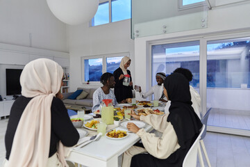 Naklejka premium In the sacred month of Ramadan, a Muslim family joyously comes together around a table, eagerly awaiting the communal iftar, engaging in the preparation of a shared meal, and uniting in anticipation