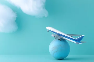 Foto op Aluminium  タイトル 飛行機とスーツケースと雲の模型を使った青い背景の海外旅行のイメージ © Free1970