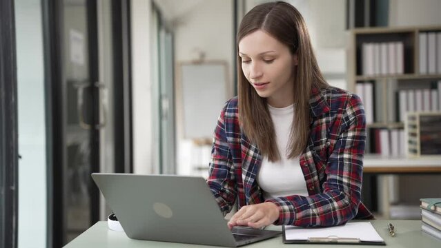 Remote career smiling woman using laptop at home Young freelance woman working with laptop at home office. High quality 4k image, online working concept.