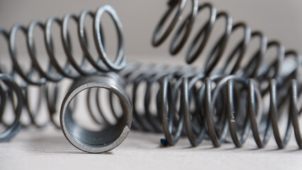 Coiled metal spring on metal surface, close-up view