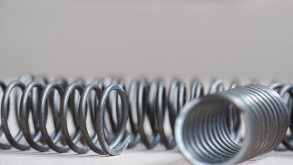 Coiled metal spring on metal surface, close-up view