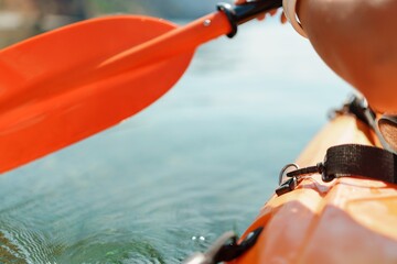 Kayak paddle sea vacation. Person paddles with orange paddle oar on kayak in sea. Leisure active...