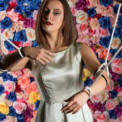 Girl in the image of marionette on flower wall