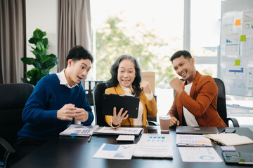 Happy businesspeople while collaborating on a new project in an office. using a laptop and tablet