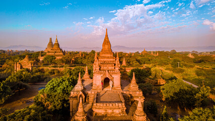 Bagan Myanmar, a couple of men and women are looking at the sunrise on top of an old pagoda temple.