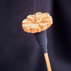 The vintage wooden spindle is a valuable tool for hand spinning and sewing enthusiasts. - obrazy, fototapety, plakaty
