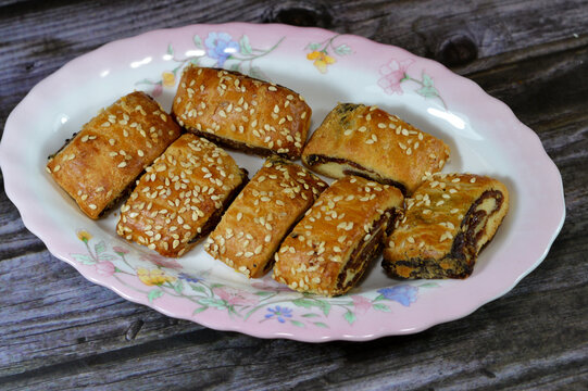 Pastry stuffed with dates and topped with sesame seeds or Ka'ab El Ghazal, Egyptian date or Agwa Ajwa filled cookies, famous middle eastern date filled pastries covered with sesame, selective focus