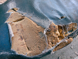 the motorbike seat is damaged. The motorbike seat foam looks damaged. Close up