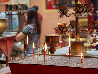 people praying at chinese temple, candles and incense