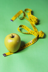 Healthy fruit, green apple with yellow measuring tape