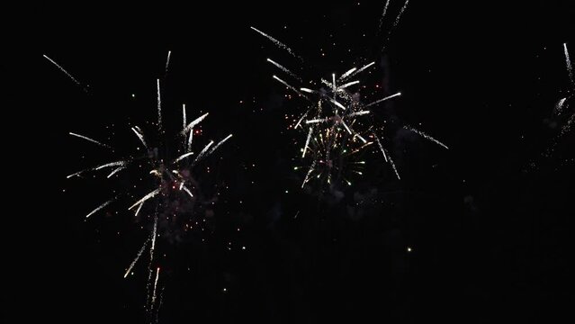 4K Real Fireworks Background Blurred image of beautiful glowing golden fireworks with bokeh lights in the night sky, New Year's Eve celebration, slow motion.