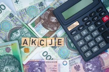 Polish word "akcje" stock Polish zloty banknote background currency with calculator
