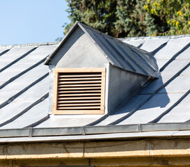 Ventilation pipe with grille on the roof of a building