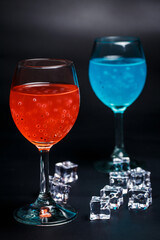 Turquoise and red cocktail on black background