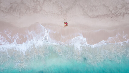 Drone aerial view at a couple on the beach at Freedom Beach in Phuket Thailand during vacation, top...