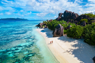 Anse Source d'Argent Beach La Digue Seychelles, a young couple of men and women on a tropical beach during a luxury vacation in Seychelles. Tropical beach Anse Source d'Argent La Digue Seychelles