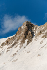 Beautiful mountain landscape, snowy slope with a peak without snow
