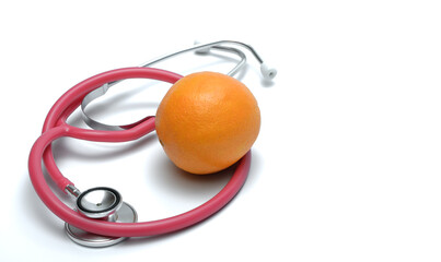 Pomarańcza leży obok stetoskopu na białym tle  - obrazy, fototapety, plakaty