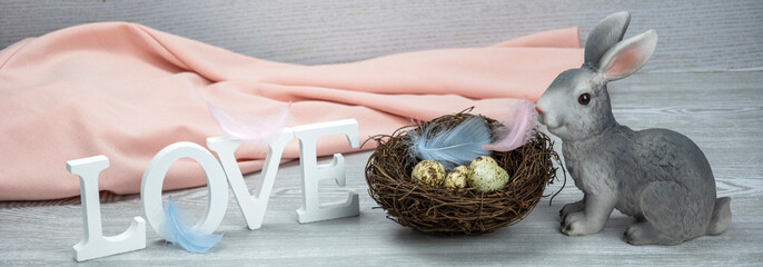 Word love, easter bunny, feathers and easter eggs. Wooden letters of the alphabet in the form of...