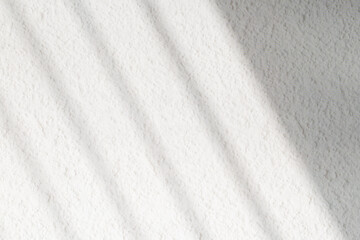 Naklejka premium Textured white wall with organic drop diagonal shadow of window
