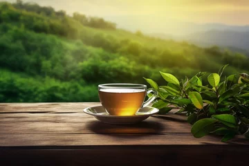 Foto op Canvas Cup of hot tea and tea leaf on the wooden table and the tea plantations background © muhmmad