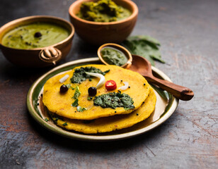 makki di roti with sarson ka saag, popular punjabi main course recipe in winters made using corn breads mustard leaves curry. served over moody background - obrazy, fototapety, plakaty