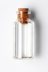 Top-down view of a round glass bottle containing clear transparent essential oil for cosmetics and natural medicine.