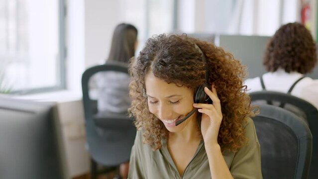 Telephone operator answering with a smile in a coworking space