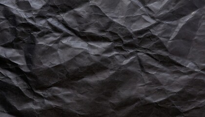Fototapeta premium A black crumpled paper background.