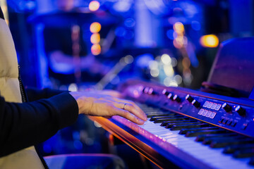Musician playing electric piano in event with blue colored background - obrazy, fototapety, plakaty