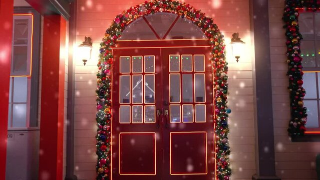 Red door and decorated balls and lights for Christmas. Christmas decorations and glowing garlands in snowvy day. Happy New Year. Noel. Winter holiday. Festival mood