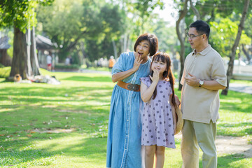 Obraz premium Happy family spending the weekend together in a public park outdoors. Concept of a healthy life and insurance plans.