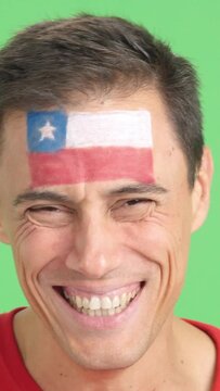 Man with a chilean flag painted on the face smiling