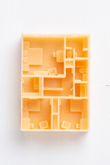 Top view of first floor of 3D model of the house interior printed on a 3D printer with orange filament by SLA technology isolated on white.