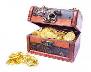Wooden half-opened pirate chest full of gold coins inside and a pile outside in front of the chest. Isolated on white background.