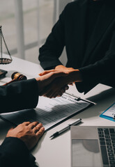 Businessman shaking hands to seal a deal with his partner lawyers or attorneys discussing a...