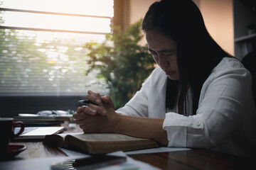 Businesswoman Praying with Eyes Closed. Businesswoman with her hands folded waiting for good news...
