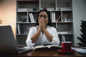 Businesswoman Praying with Eyes Closed. Businesswoman with her hands folded waiting for good news...