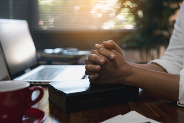 Businesswoman with closeup her hands folded waiting for good news sitting at workplace at the table...